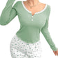 Woman wearing a green long-sleeve top and white pants with green patterns on a white background